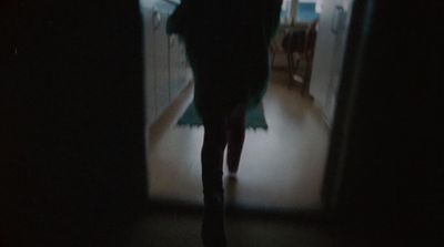 a woman walking down a hallway at night