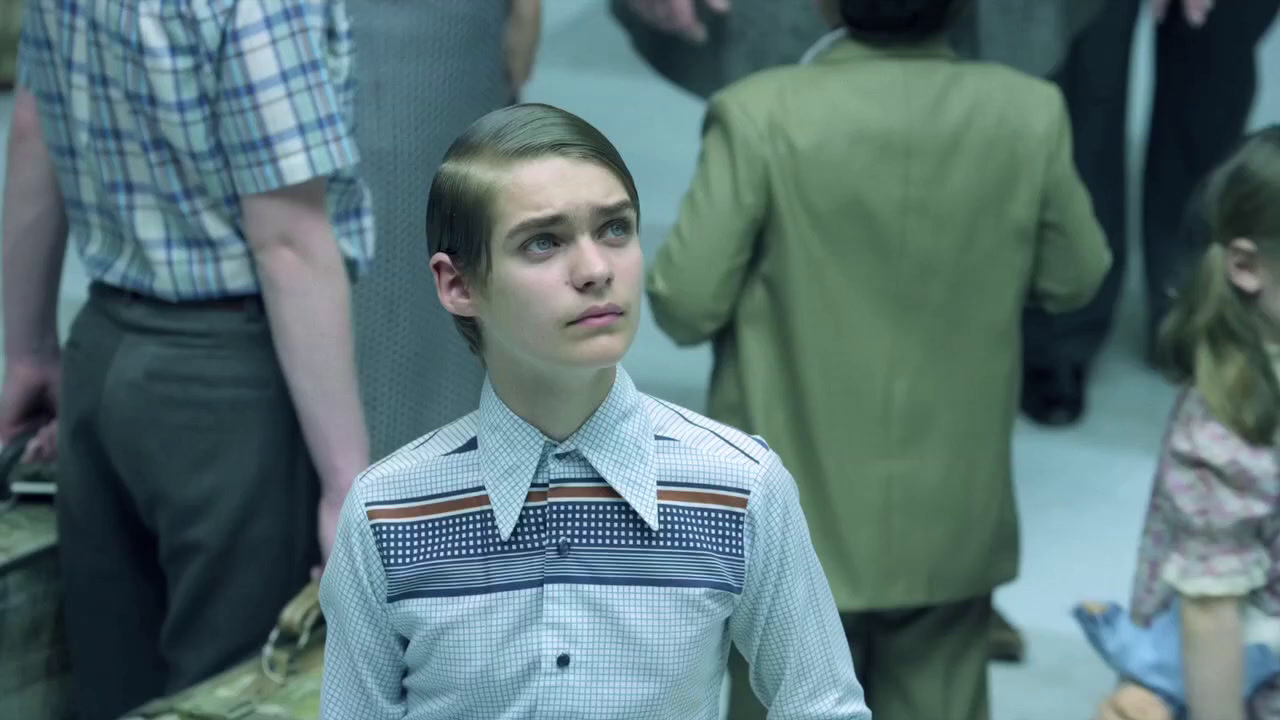 a young man standing in front of a crowd of people