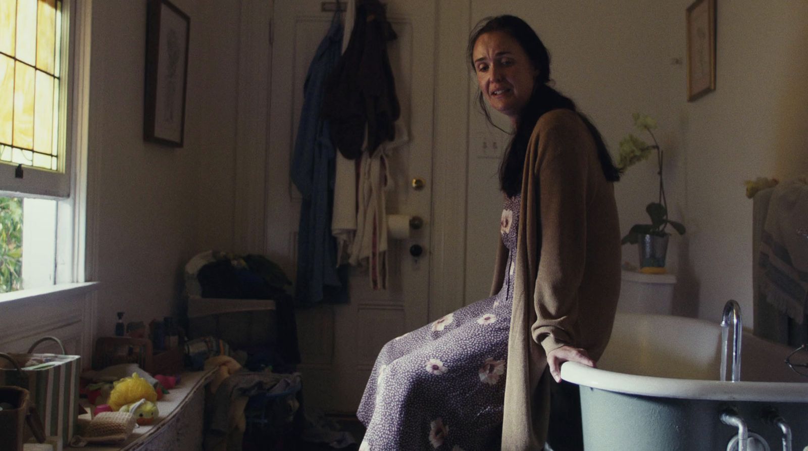 a woman standing in a bathroom next to a tub