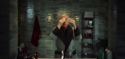 a man standing in front of a mirror covering his eyes