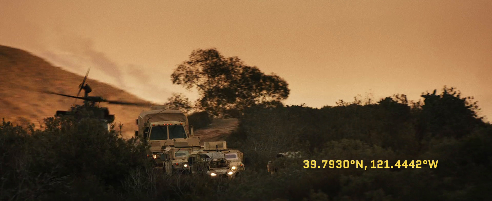 a military truck driving down a dirt road