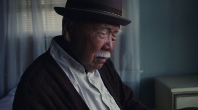 an older man wearing a hat and a sweater