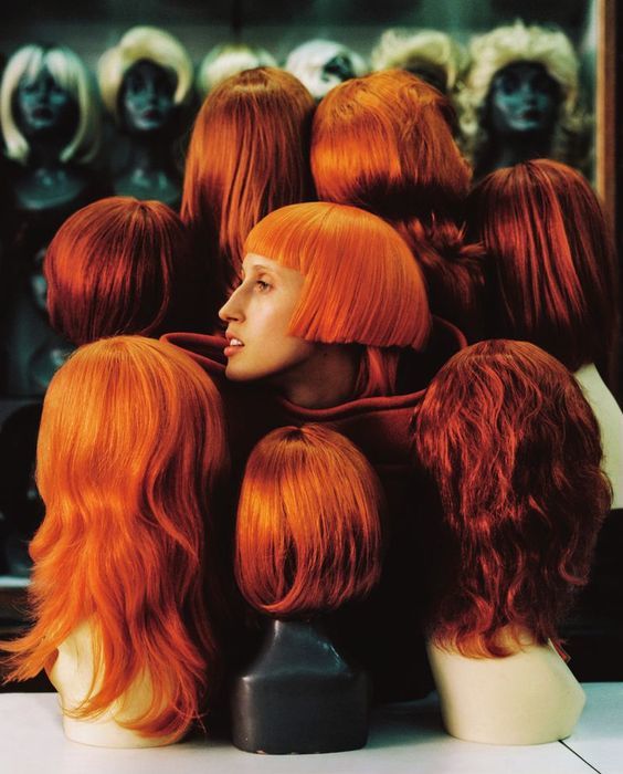 a group of mannequin heads with red hair