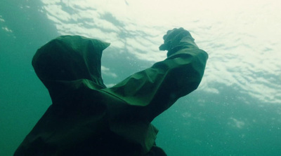 a man in a hooded jacket under water
