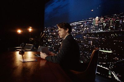 a man sitting at a table with a laptop in front of him