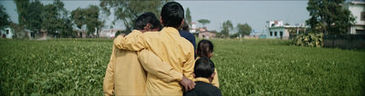 a group of people walking through a lush green field