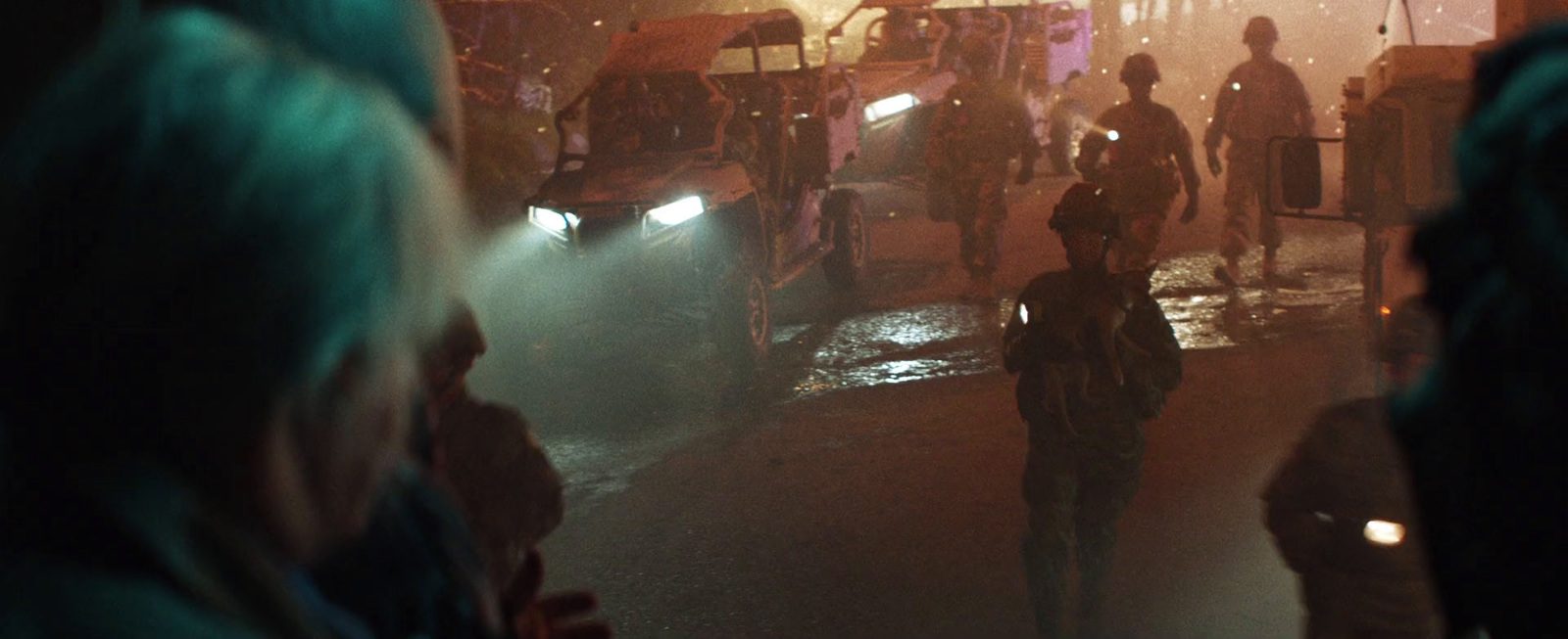 a group of people walking down a street at night