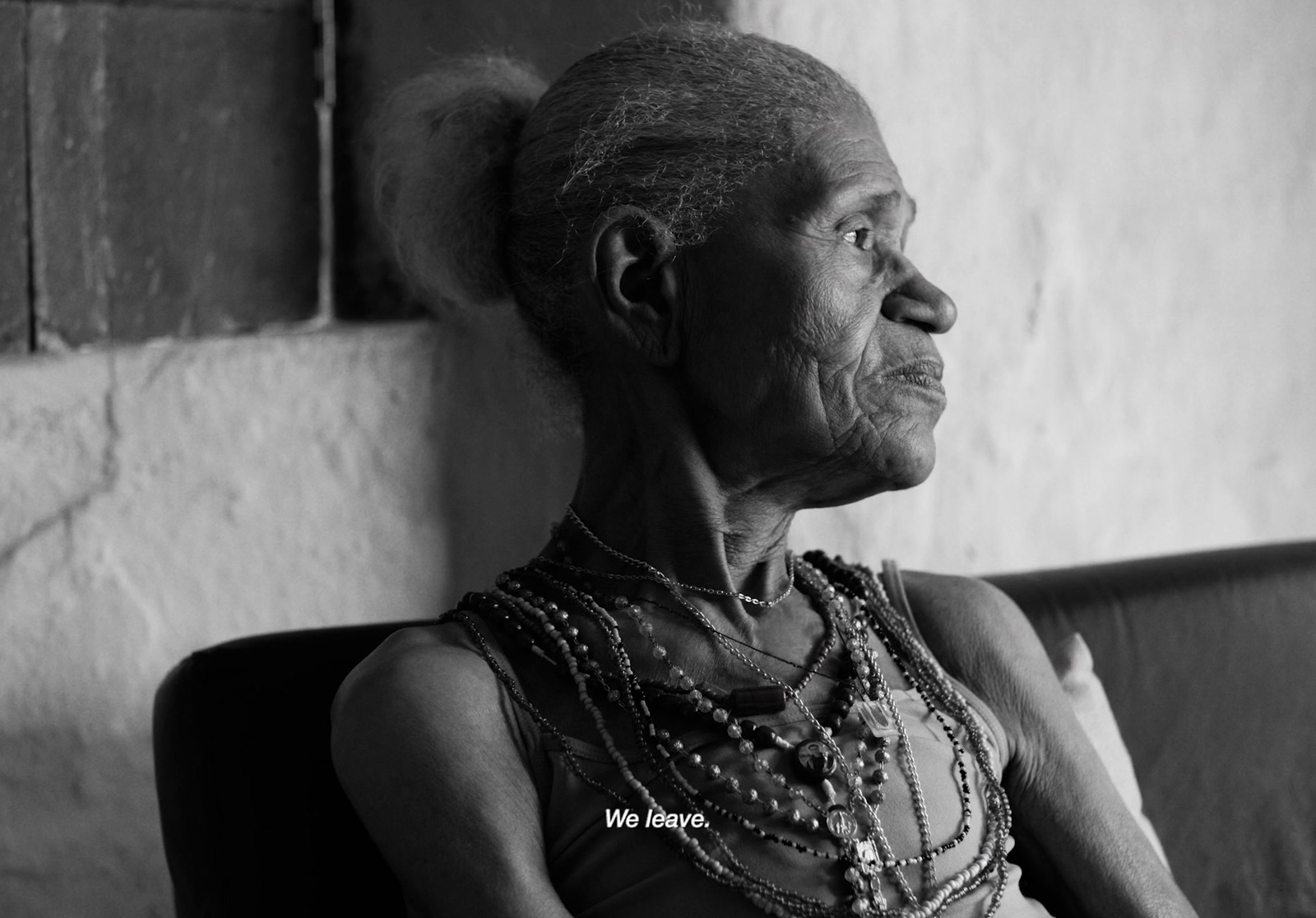 a woman sitting on a couch wearing a necklace