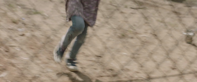 a person walking in the sand with a frisbee