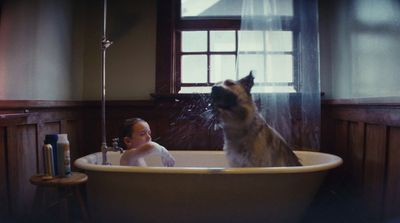 a small child and a dog in a bathtub