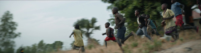 a group of people running down a dirt road