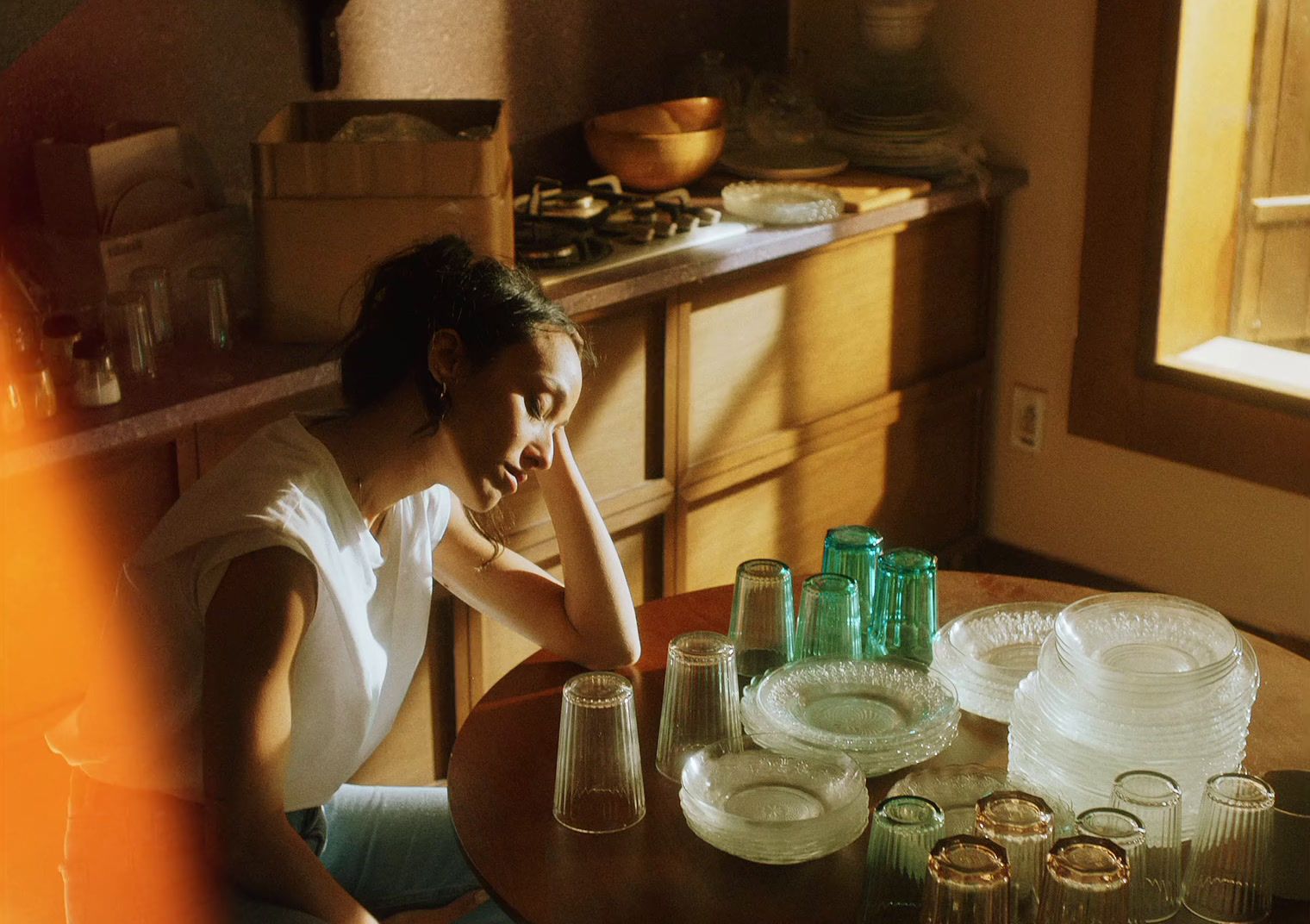 a woman sitting at a table in a kitchen