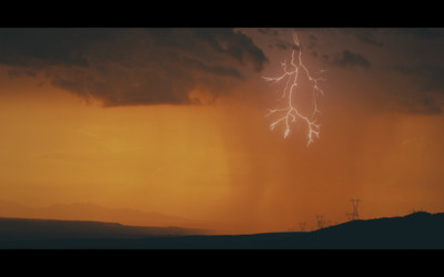 a lightning bolt is seen in the sky over a mountain