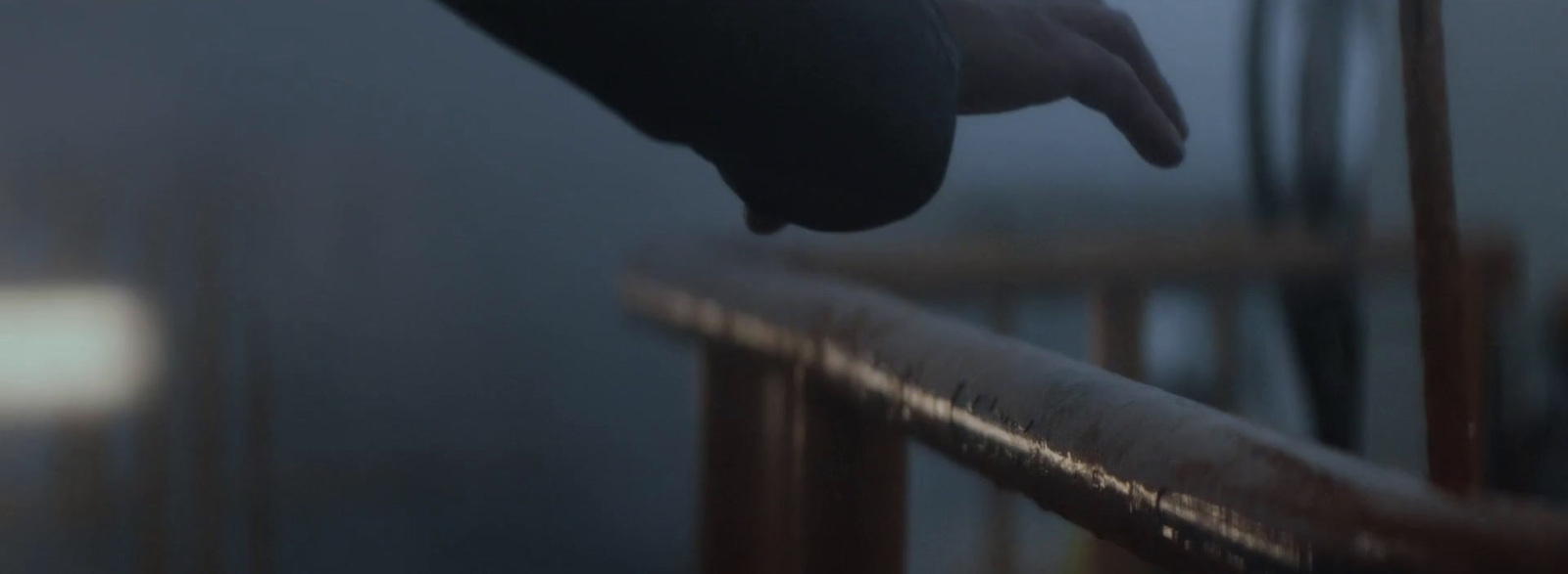 a hand reaching for something on a railing