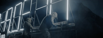 two people standing on a ladder in a dark room