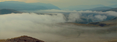 a view of a mountain range covered in clouds