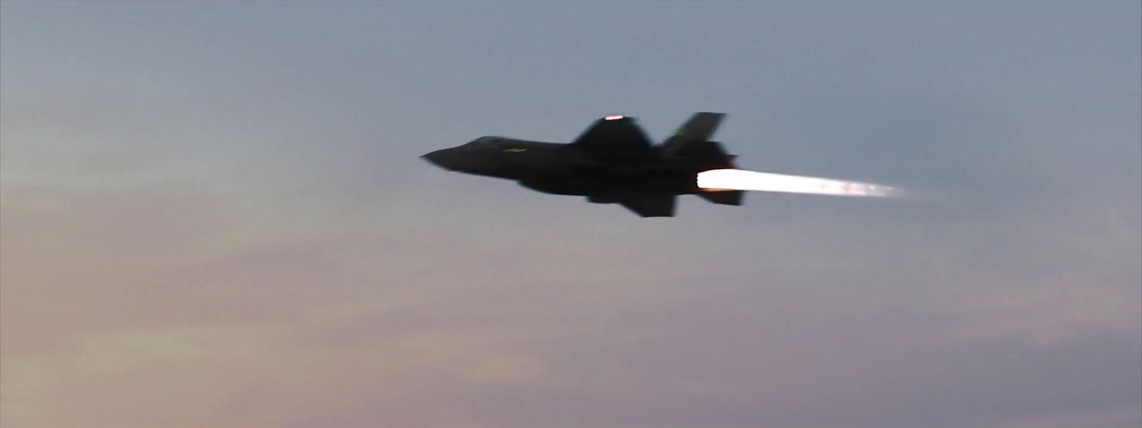 a fighter jet flying through a cloudy sky