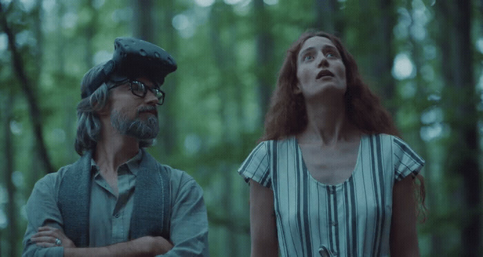 a woman standing next to a man in a forest