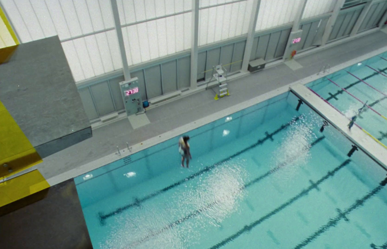 a man standing in a swimming pool next to a tall building