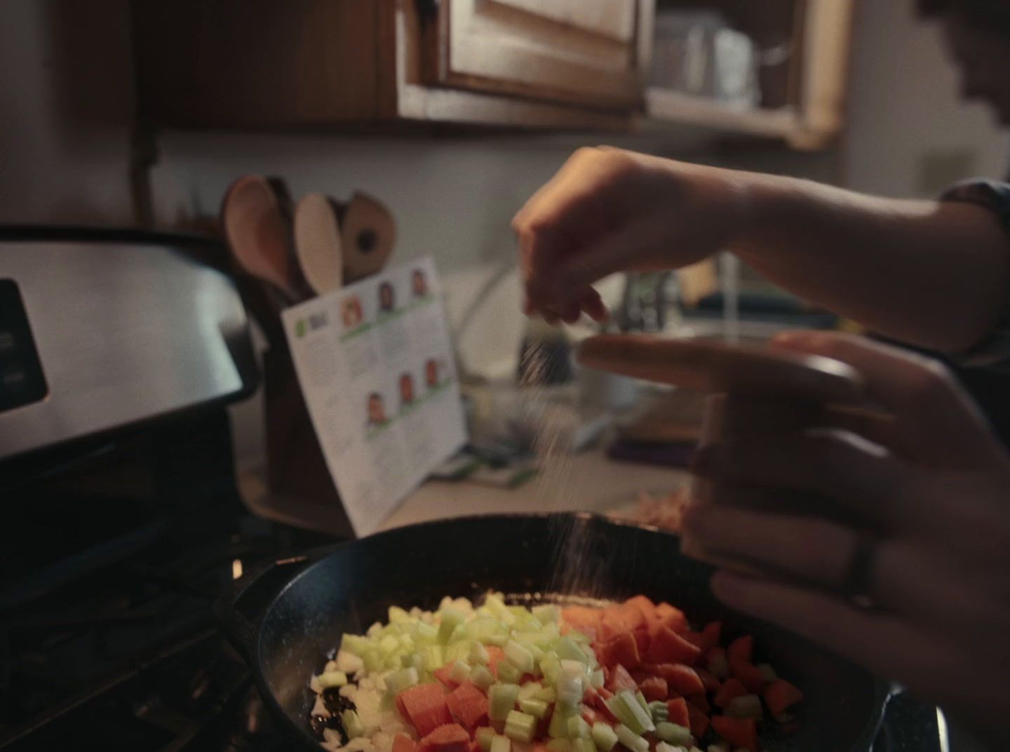 a person cooking vegetables in a frying pan