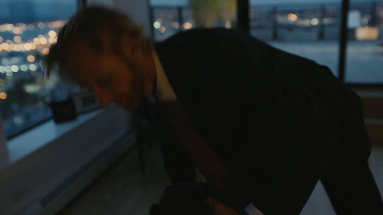 a man in a suit leaning over a window