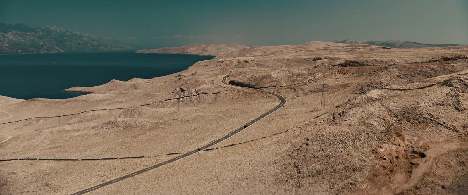 an aerial view of a winding road in the desert