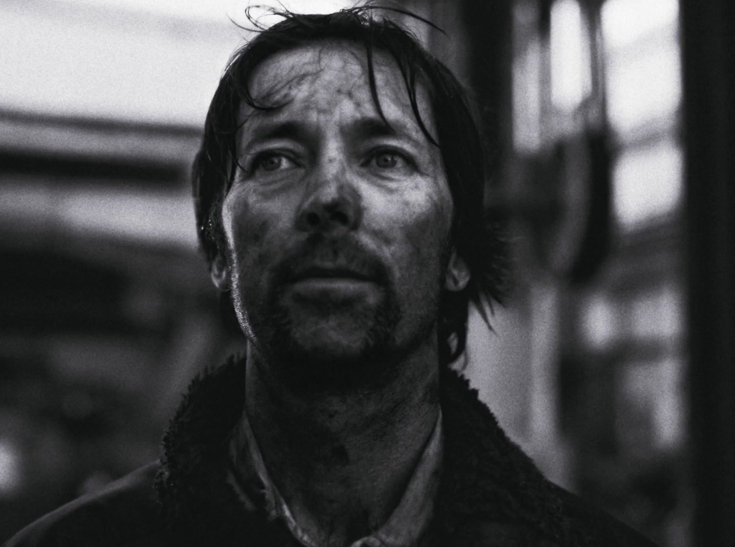 a black and white photo of a man looking up