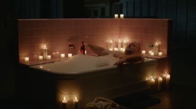 a man laying in a bathtub surrounded by candles