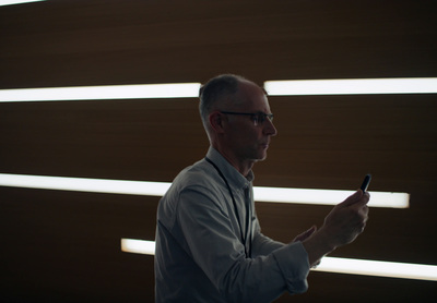 a man in a white shirt is holding a cell phone