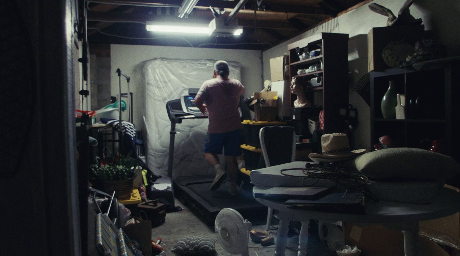 a man standing in a room filled with lots of clutter