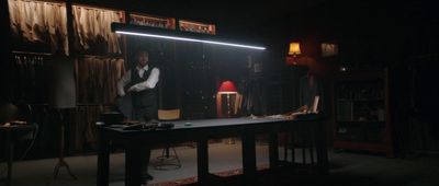 a man standing in front of a desk in a dark room