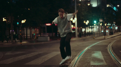 a man riding a skateboard down a street at night