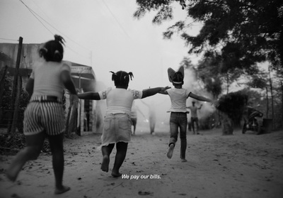 two young girls running down a dirt road