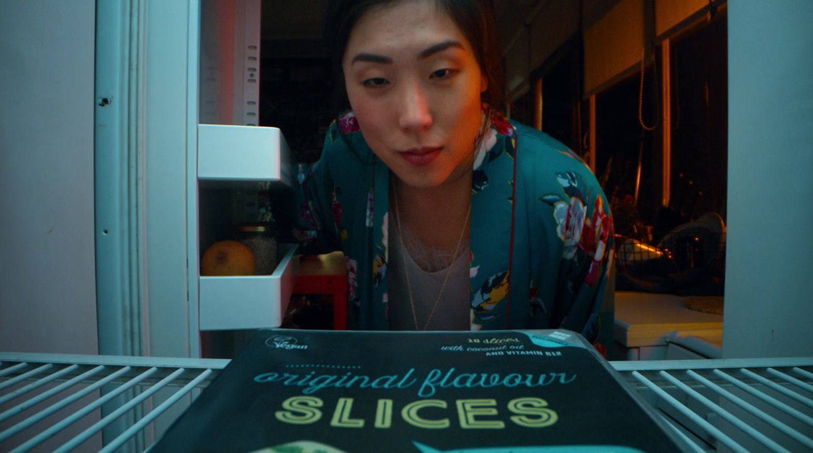 a woman looking at a book in a refrigerator