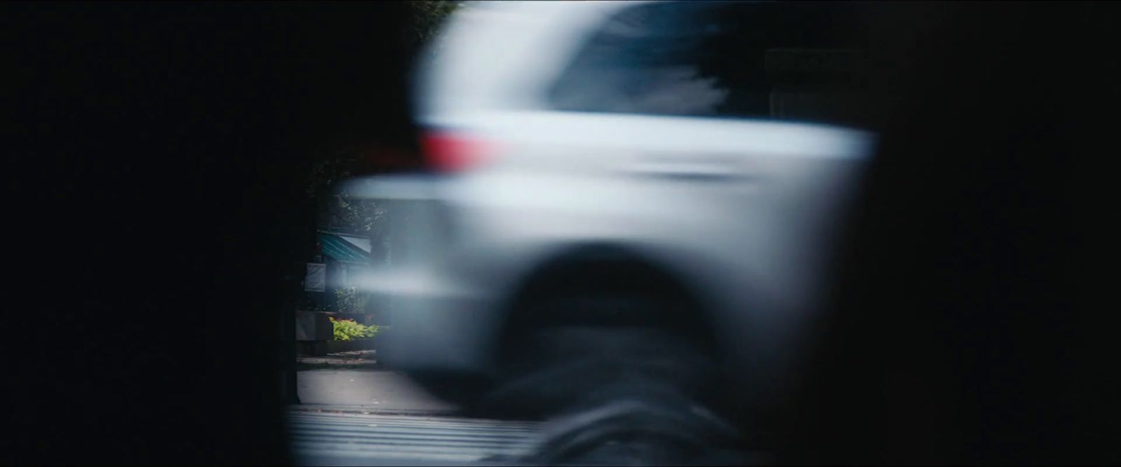 a blurry photo of a white car driving down a street