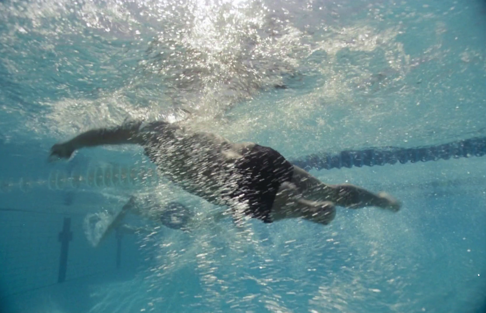 a man swimming under water in a pool