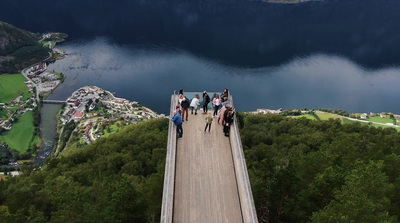 a group of people standing on a bridge over a lake