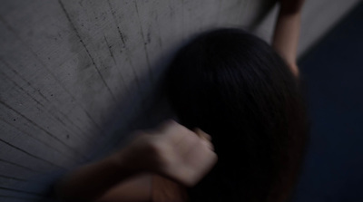 a woman leaning against a wall with her hand on the wall