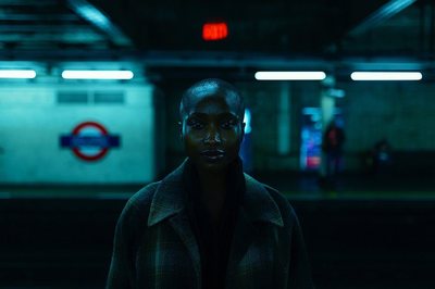 a person standing in a dark room with a sign in the background