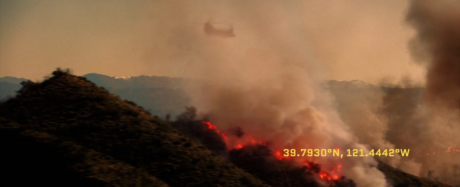 a helicopter flying over a forest filled with smoke