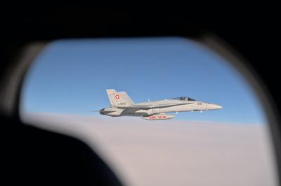 a fighter jet flying through a blue sky