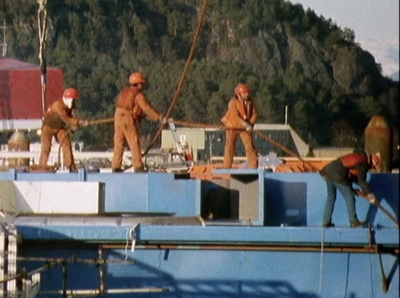 a group of men standing on top of a boat