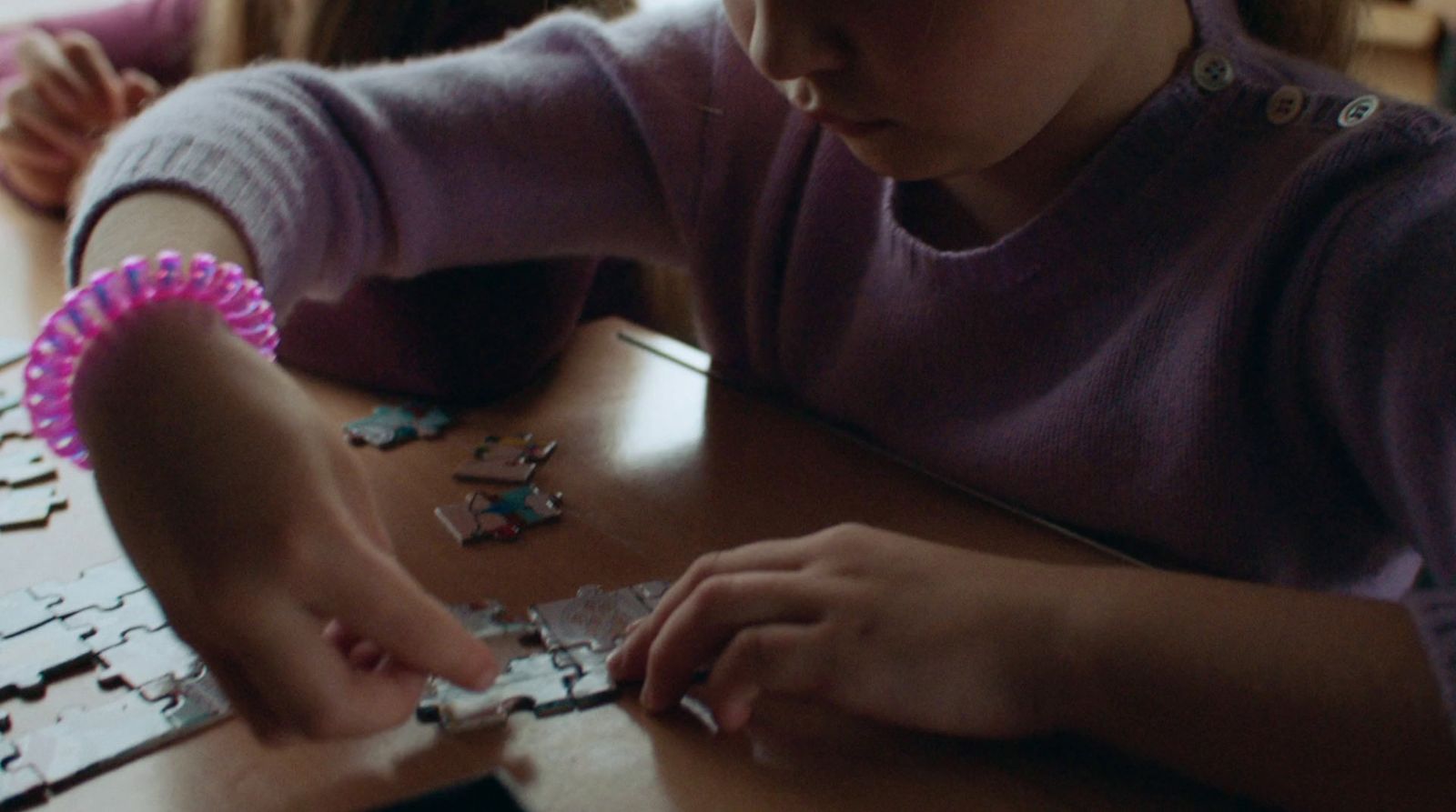 a young girl is playing with a puzzle