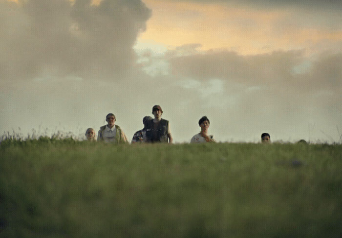 a group of people sitting on top of a lush green field