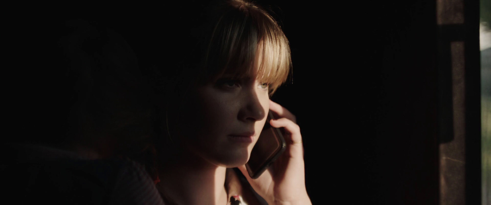 a woman talking on a cell phone in a dark room