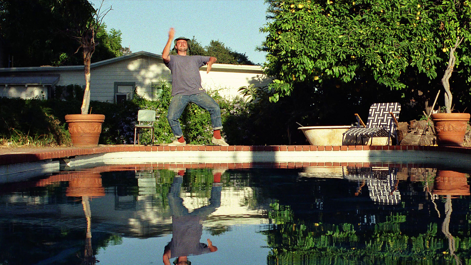 a man standing on a skateboard in front of a pool