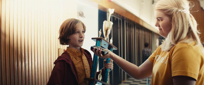 a young boy and a young girl holding up a clock