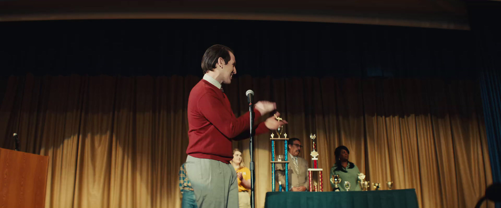 a man standing in front of a microphone on a stage