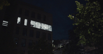 a group of people standing outside of a building at night