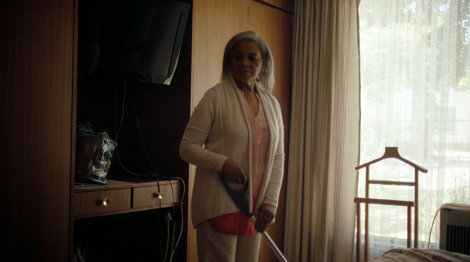 a woman standing in front of a tv holding a remote control